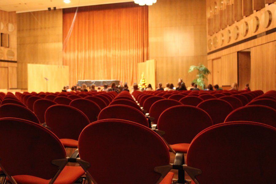 Eine Gruppe Kinder sitzt im Mendelssohn-Saal des Gewandhauses, davor sind viele leere Reihen mit Polsterstühlen.